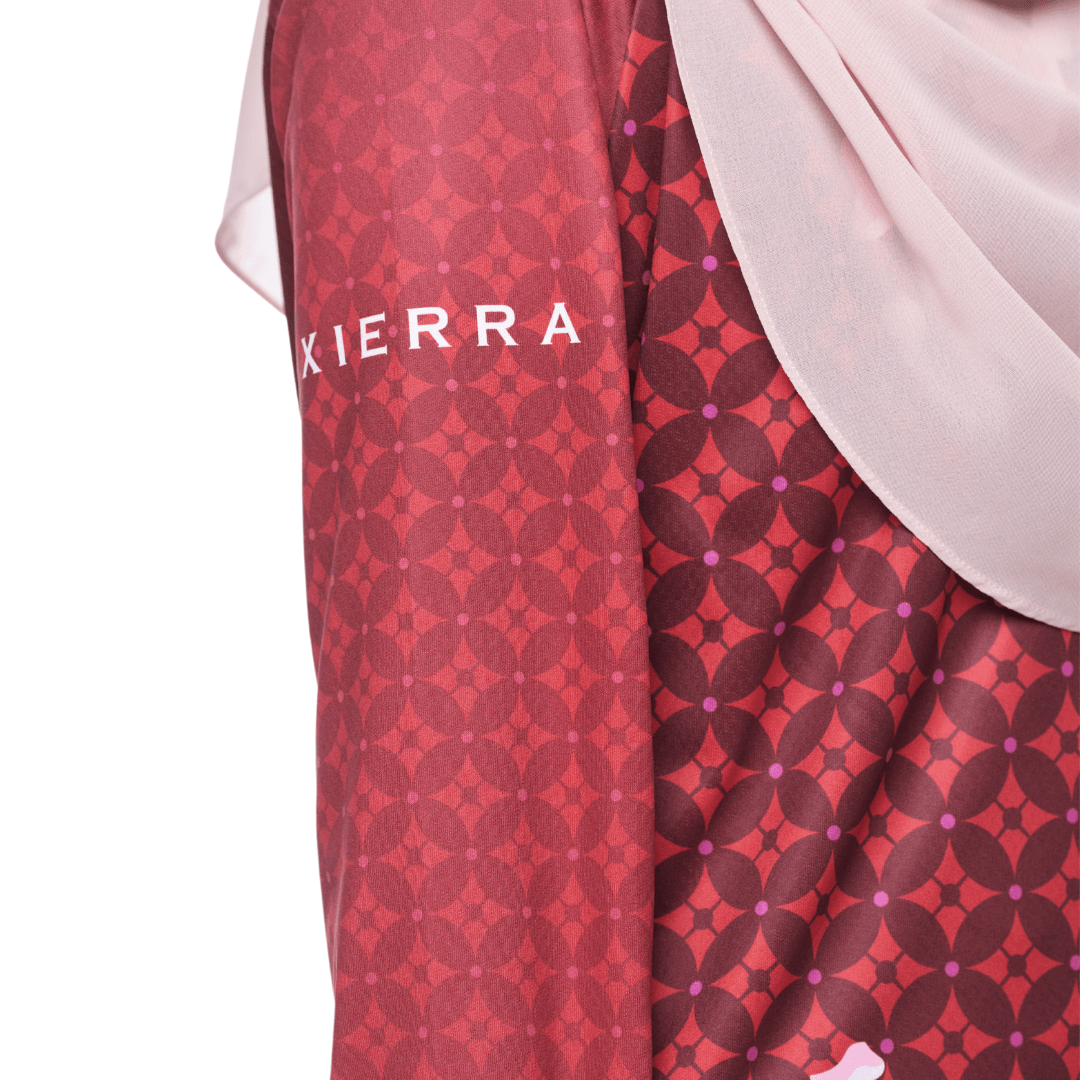 A close up on the sleeve of a red modest shirt, the word Xierra is printed.